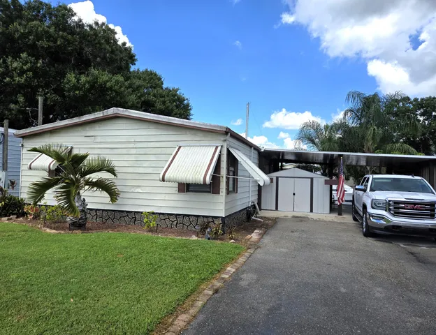 a front view of a house with a garden and car parked