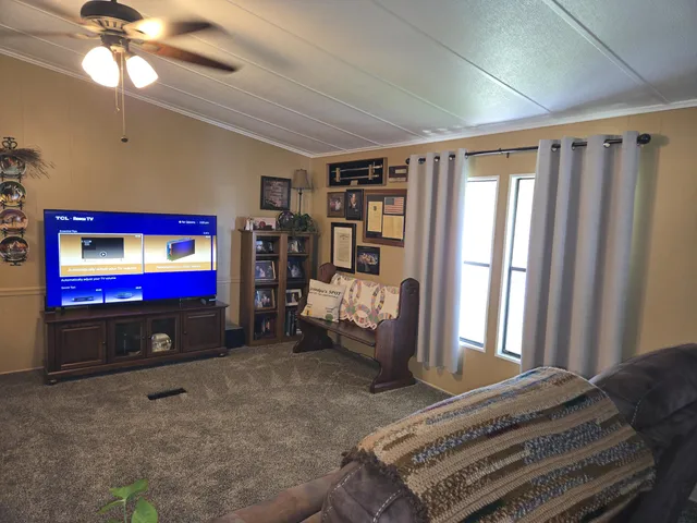 a living room with stainless steel appliances kitchen island granite countertop furniture and a fireplace