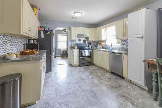 a kitchen with a refrigerator stove top oven and sink