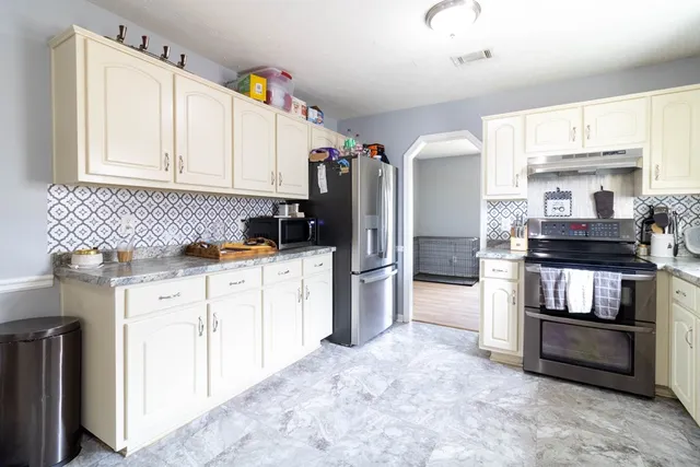 a kitchen with refrigerator and cabinets