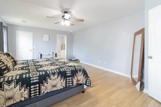 a bedroom with a large bed and a chandelier