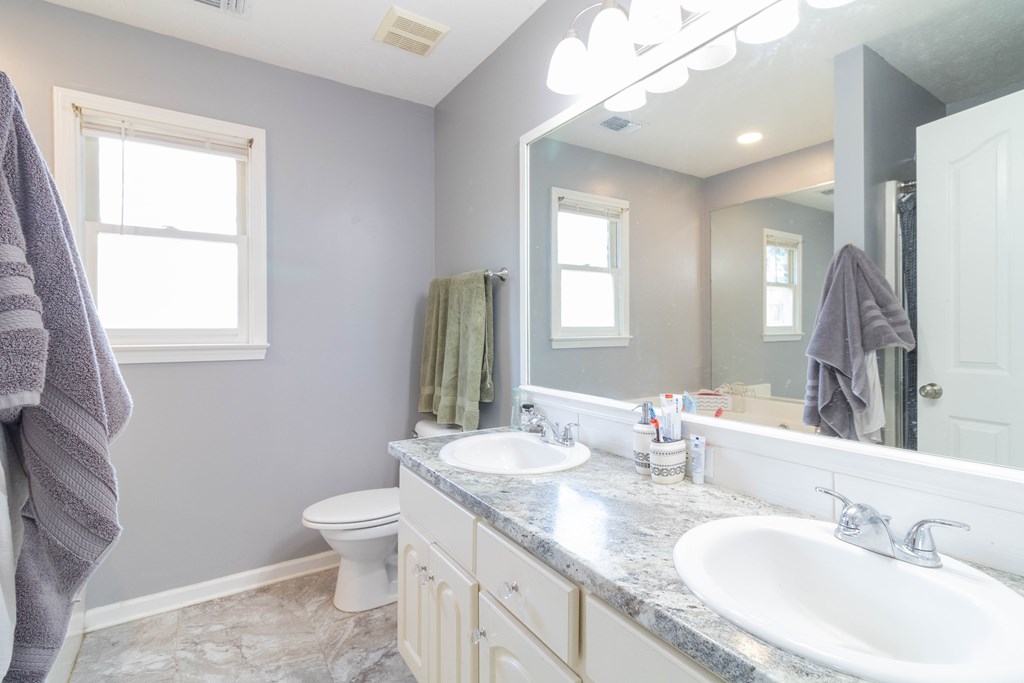3381 Flintlock Drive Columbus, GA 31907 - Photo 29 of 39 a bathroom with a double vanity sink toilet and a mirror