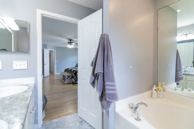 a bathroom with a tub sink and mirror