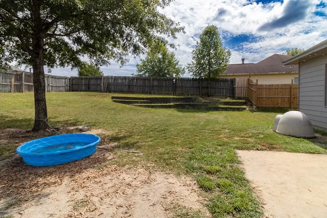 a view of a backyard with swimming pool