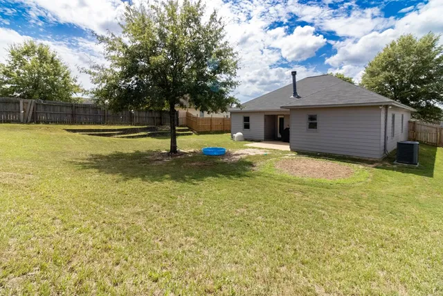 a view of a house with pool and a yard