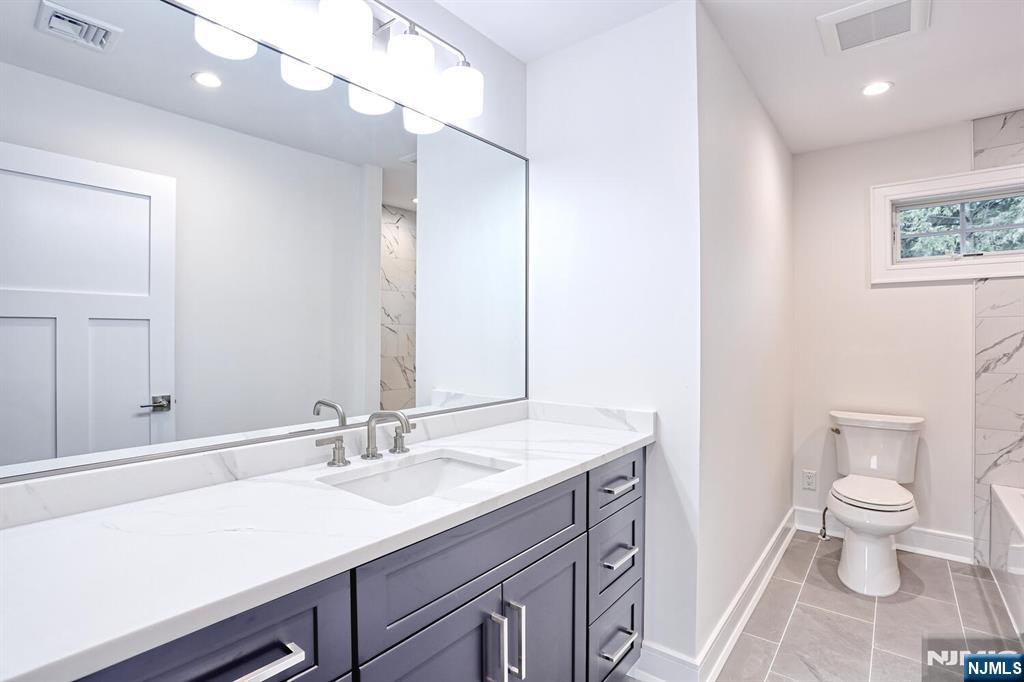 57 Mill Road Park Ridge, NJ 07656 - Photo 28 of 50 a bathroom with a sink a toilet and a mirror