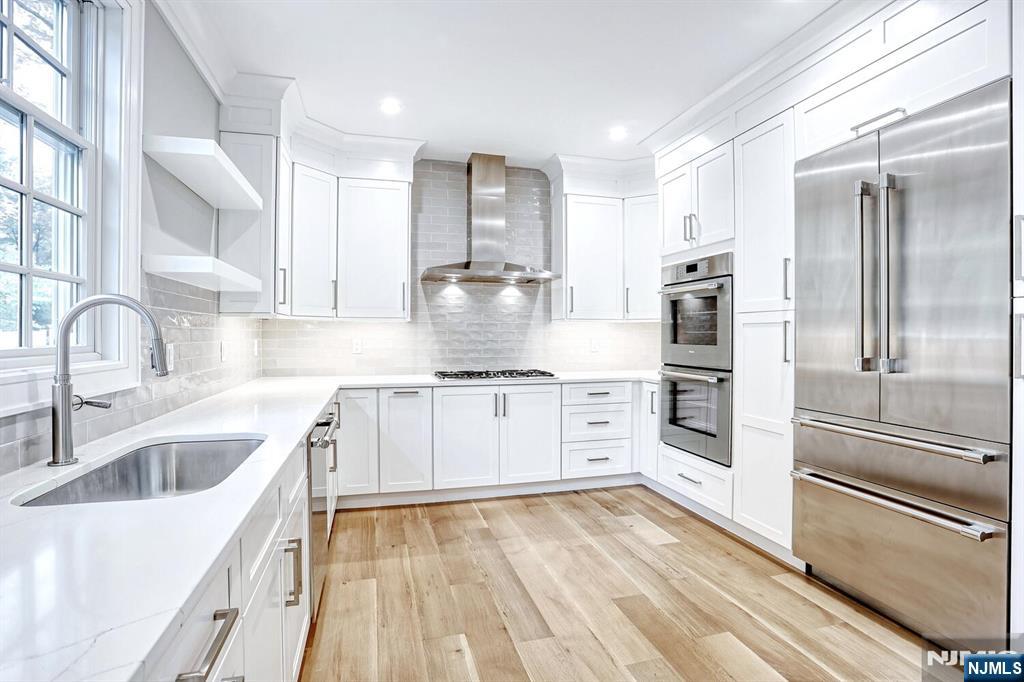 57 Mill Road Park Ridge, NJ 07656 - Photo 8 of 50 a kitchen with white cabinets and stainless steel appliances