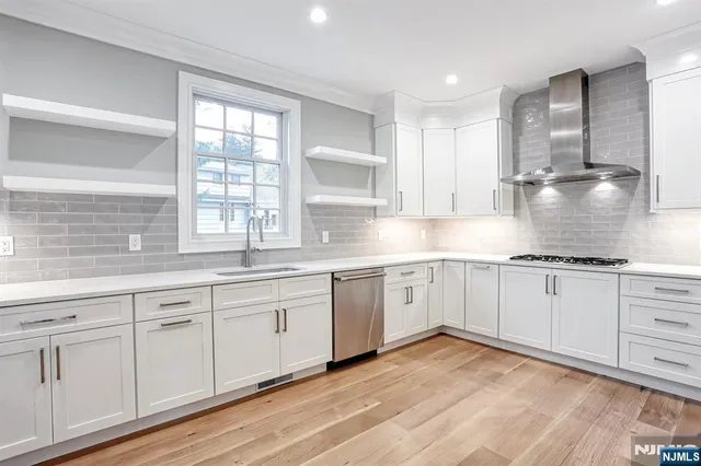 a large kitchen with granite countertop a stove top oven a sink a counter space and cabinets