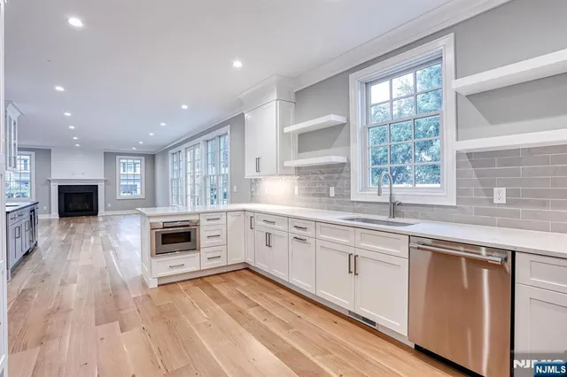 a kitchen with granite countertop a stove top oven a sink a counter space and cabinets
