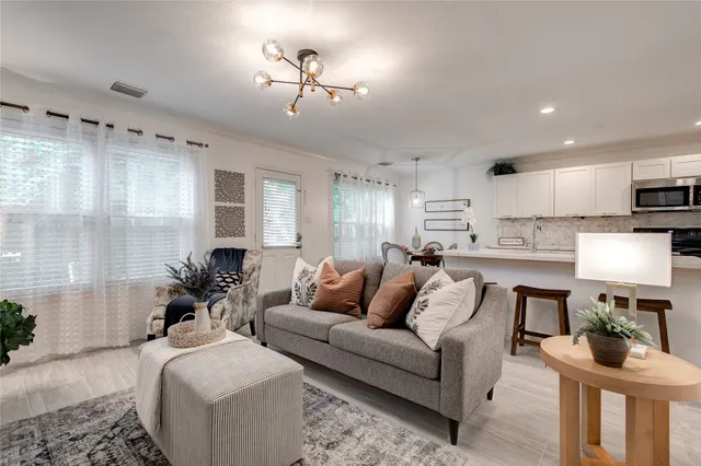 a living room with furniture and a wooden floor