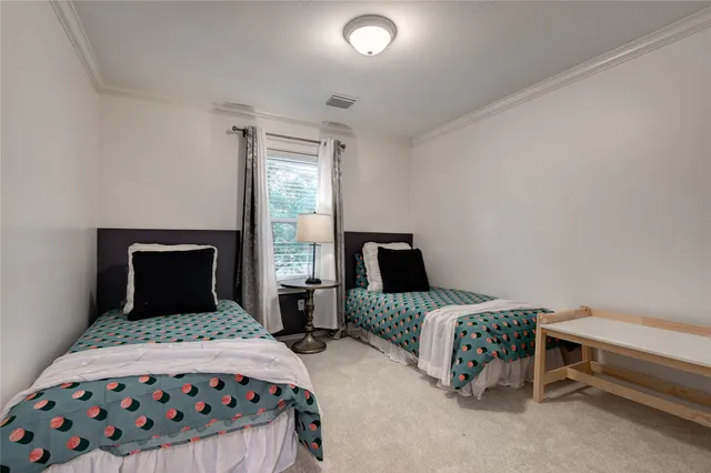 a bedroom with a bed and a lamp on dresser