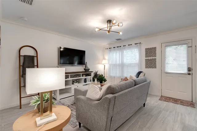 a living room with furniture a flat screen tv and kitchen view