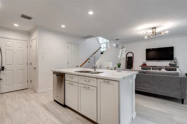 a kitchen with a sink and a stove top oven with wooden floor