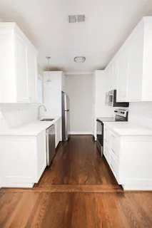 a kitchen with granite countertop white cabinets and white appliances