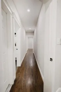 a view of a hallway with wooden floor