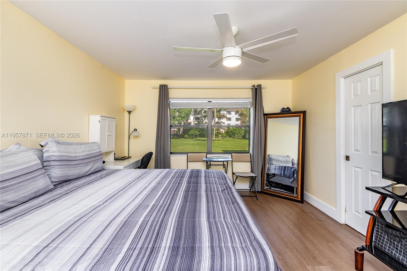 9355 Southwest 8th Street, Unit 105 Boca Raton, FL 33428 - Photo 19 of 37 a spacious bedroom with a bed and a large window