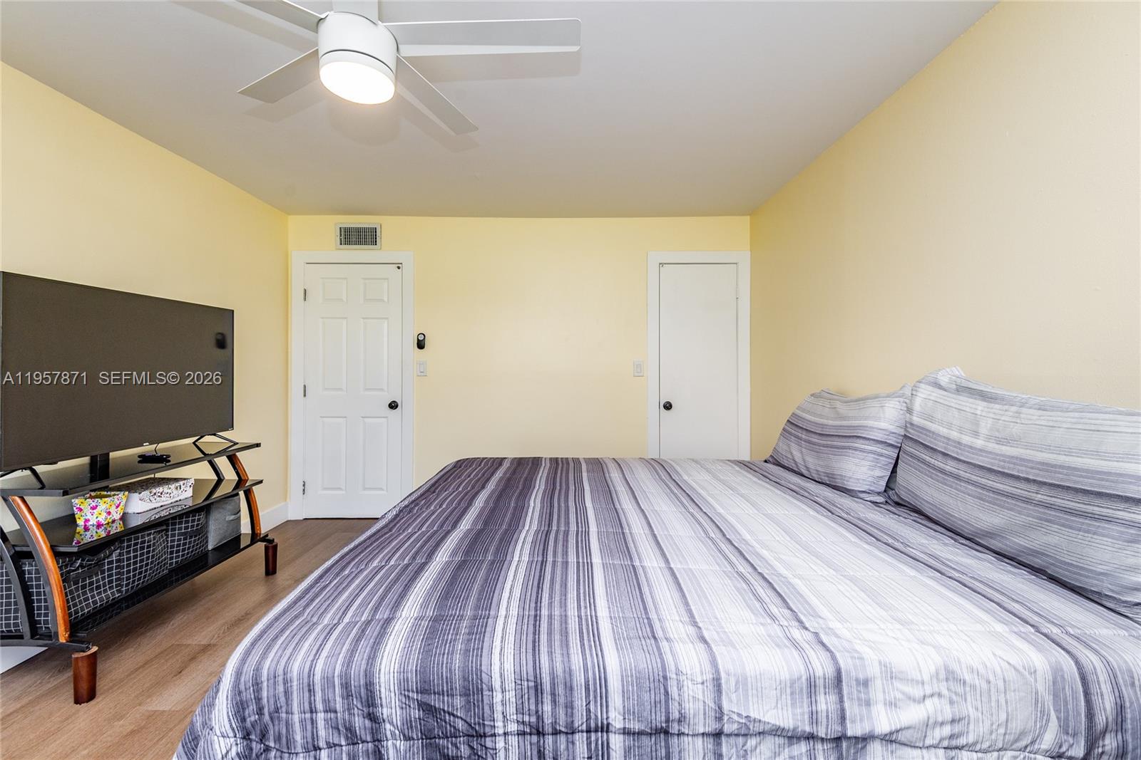 9355 Southwest 8th Street, Unit 105 Boca Raton, FL 33428 - Photo 20 of 37 a bedroom with a bed and a chandelier