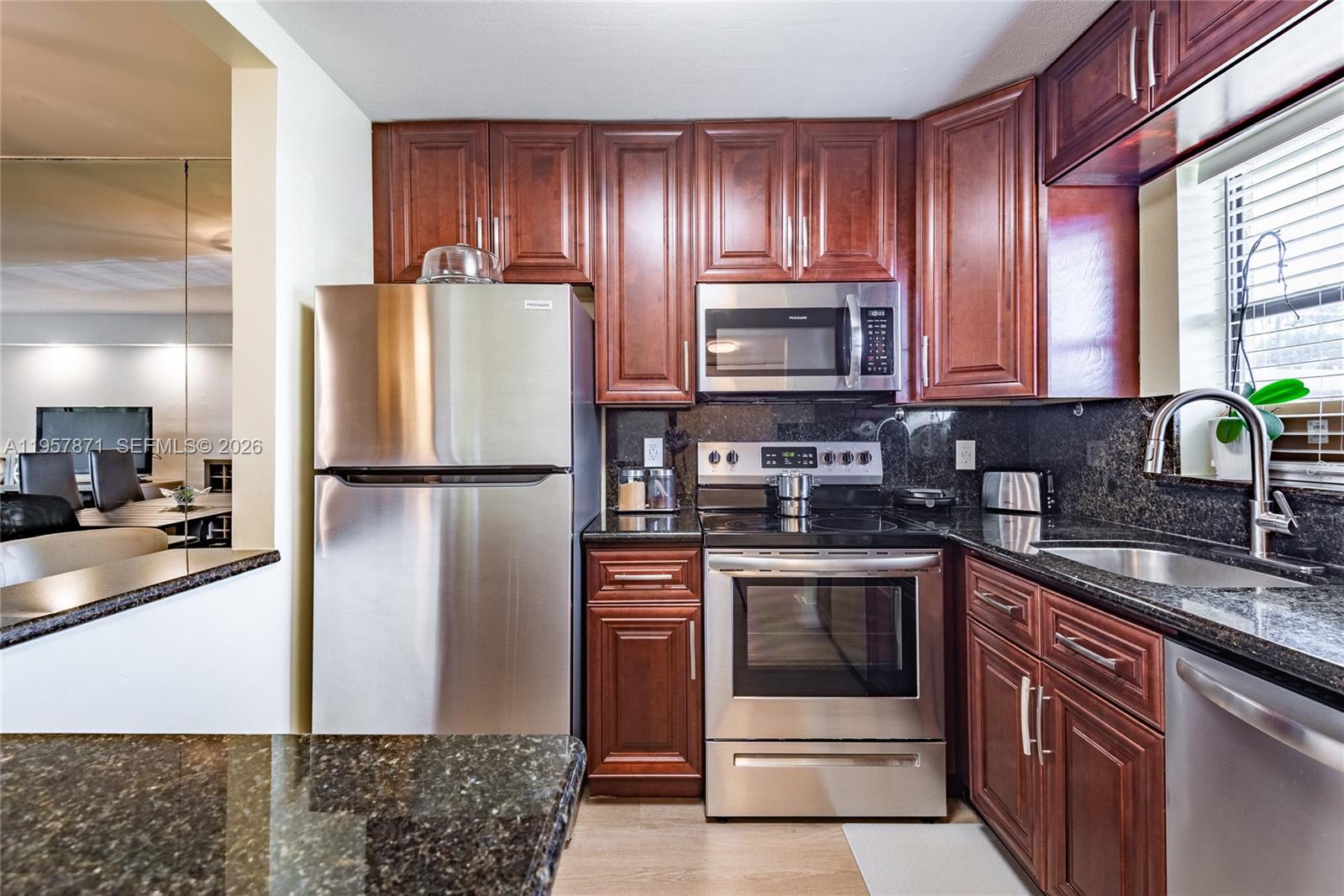9355 Southwest 8th Street, Unit 105 Boca Raton, FL 33428 - Photo 2 of 37 a kitchen with stainless steel appliances granite countertop a refrigerator stove a sink and dishwasher