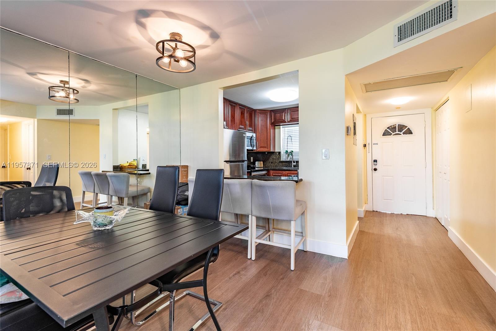 9355 Southwest 8th Street, Unit 105 Boca Raton, FL 33428 - Photo 6 of 37 a view of a dining room with furniture and wooden floor