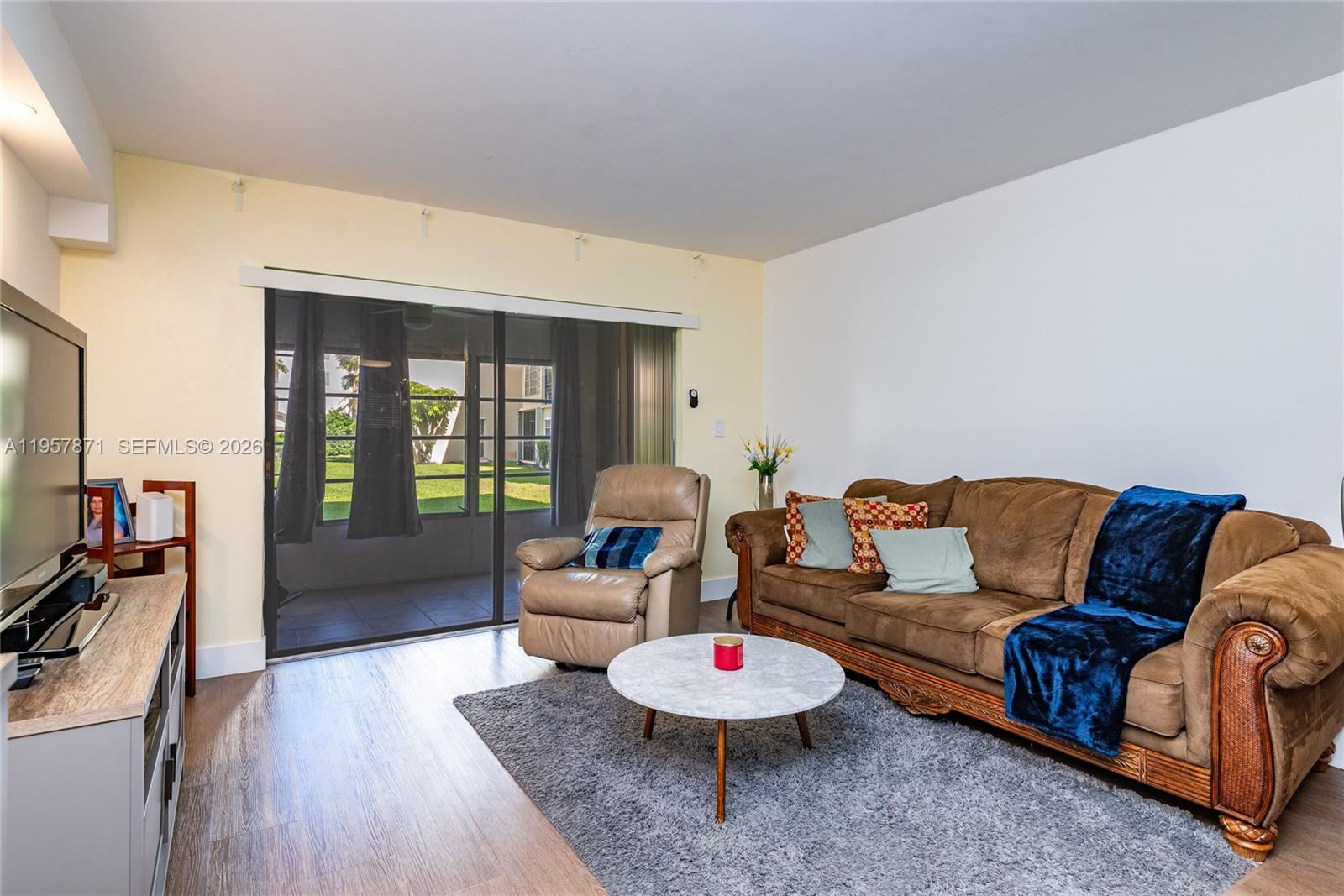 9355 Southwest 8th Street, Unit 105 Boca Raton, FL 33428 - Photo 9 of 37 a living room with furniture and a flat screen tv