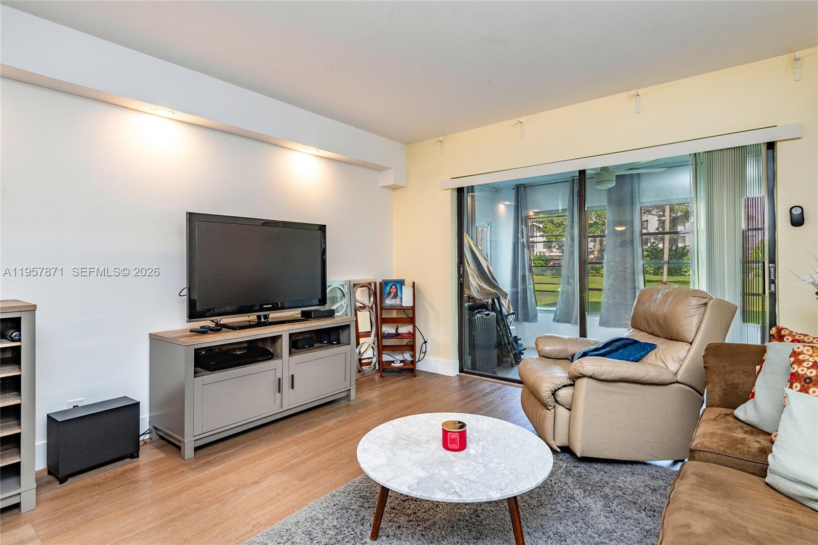 9355 Southwest 8th Street, Unit 105 Boca Raton, FL 33428 - Photo 10 of 37 a living room with furniture and a flat screen tv