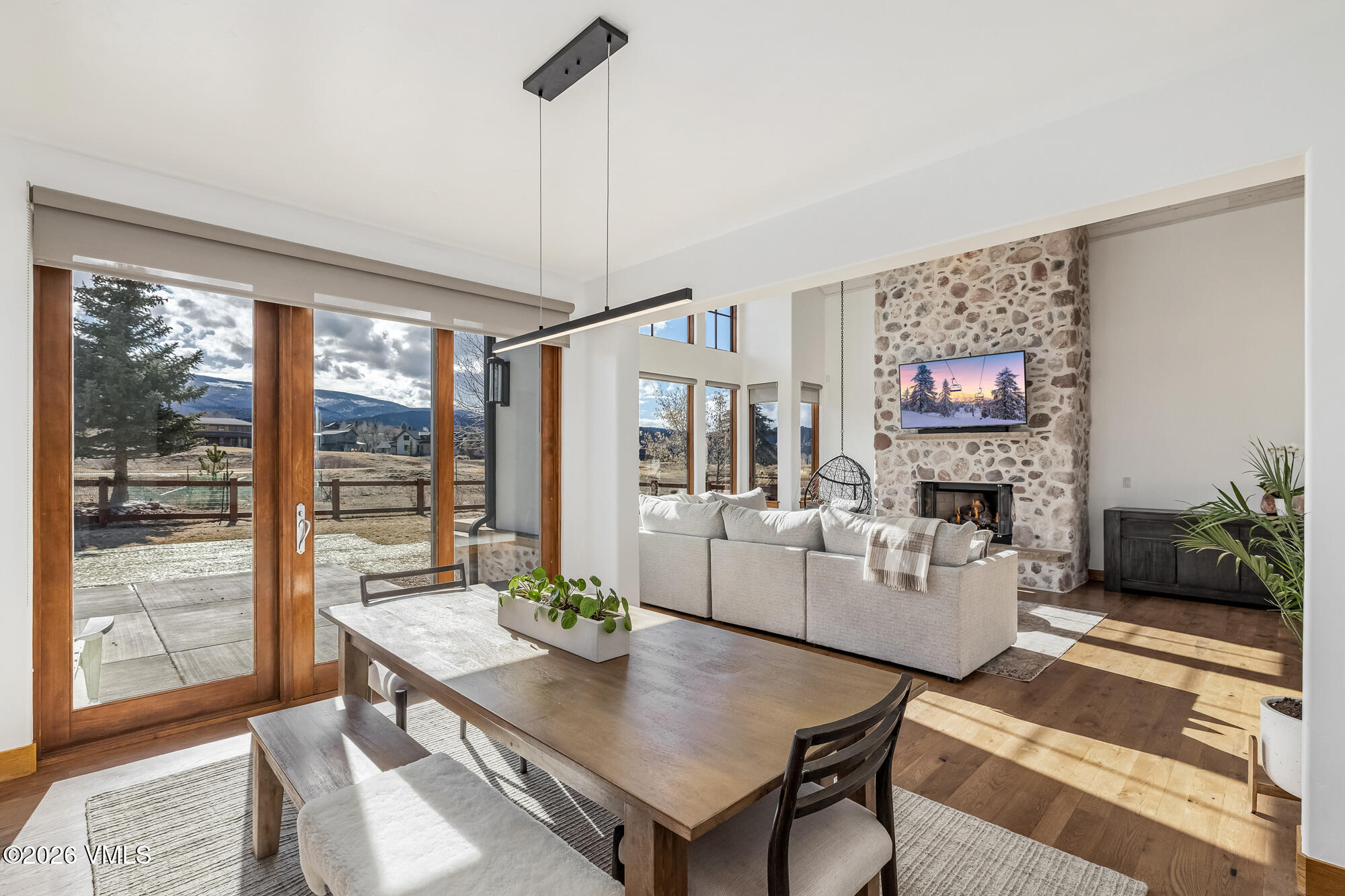 2044 Eagle Ranch Road Eagle, CO 81631 - Photo 8 of 39 a living room with furniture a dining table and a floor to ceiling window