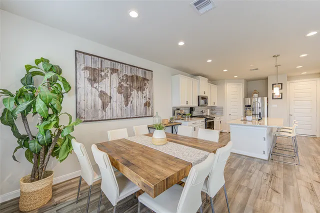 a dining room with furniture potted plants and wooden floor