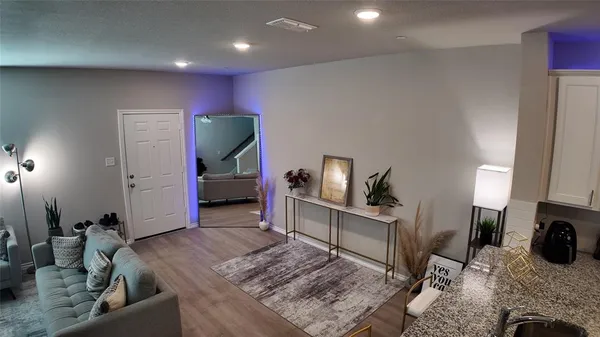 a living room with furniture and a wooden floor