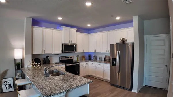 a kitchen with stainless steel appliances granite countertop a refrigerator sink and cabinets