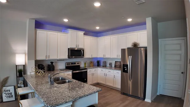 a kitchen with stainless steel appliances granite countertop a refrigerator sink and cabinets