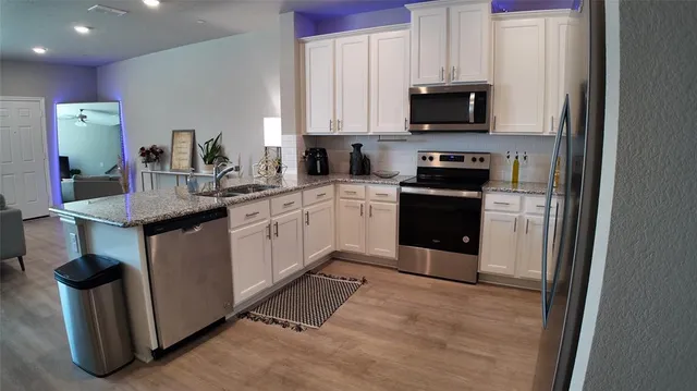 a kitchen with stainless steel appliances granite countertop a stove a sink and a microwave