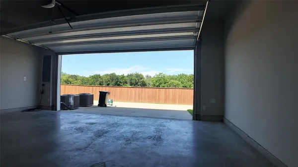 a view of empty room with wooden floor and a window