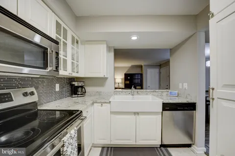 a kitchen with cabinets stainless steel appliances and a sink