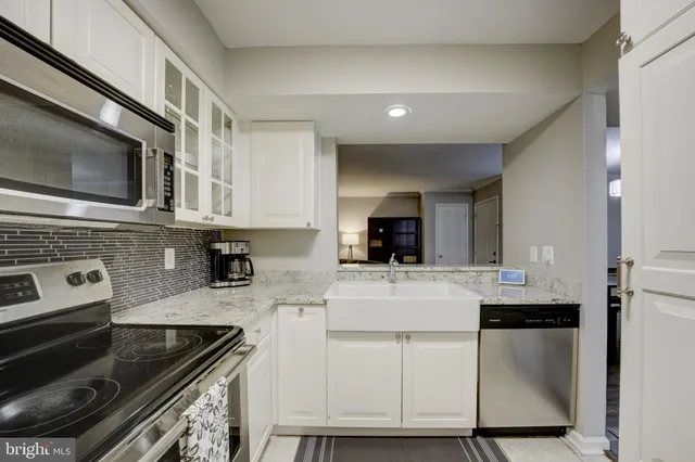 a kitchen with cabinets stainless steel appliances and a sink