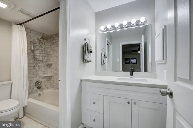 a bedroom with a bed and a flat tv screen on dresser