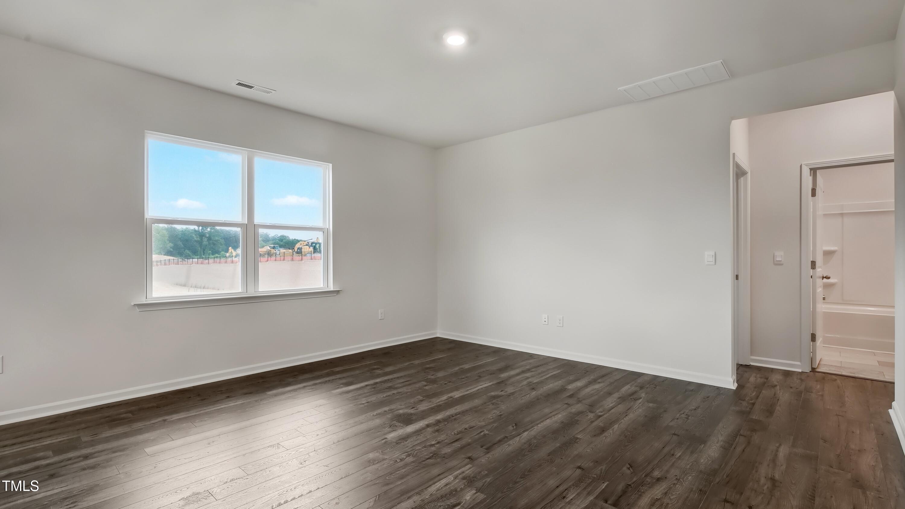 845 Comice Pear Way Willow Spring, NC 27592 - Photo 12 of 36 an empty room with wooden floor and windows