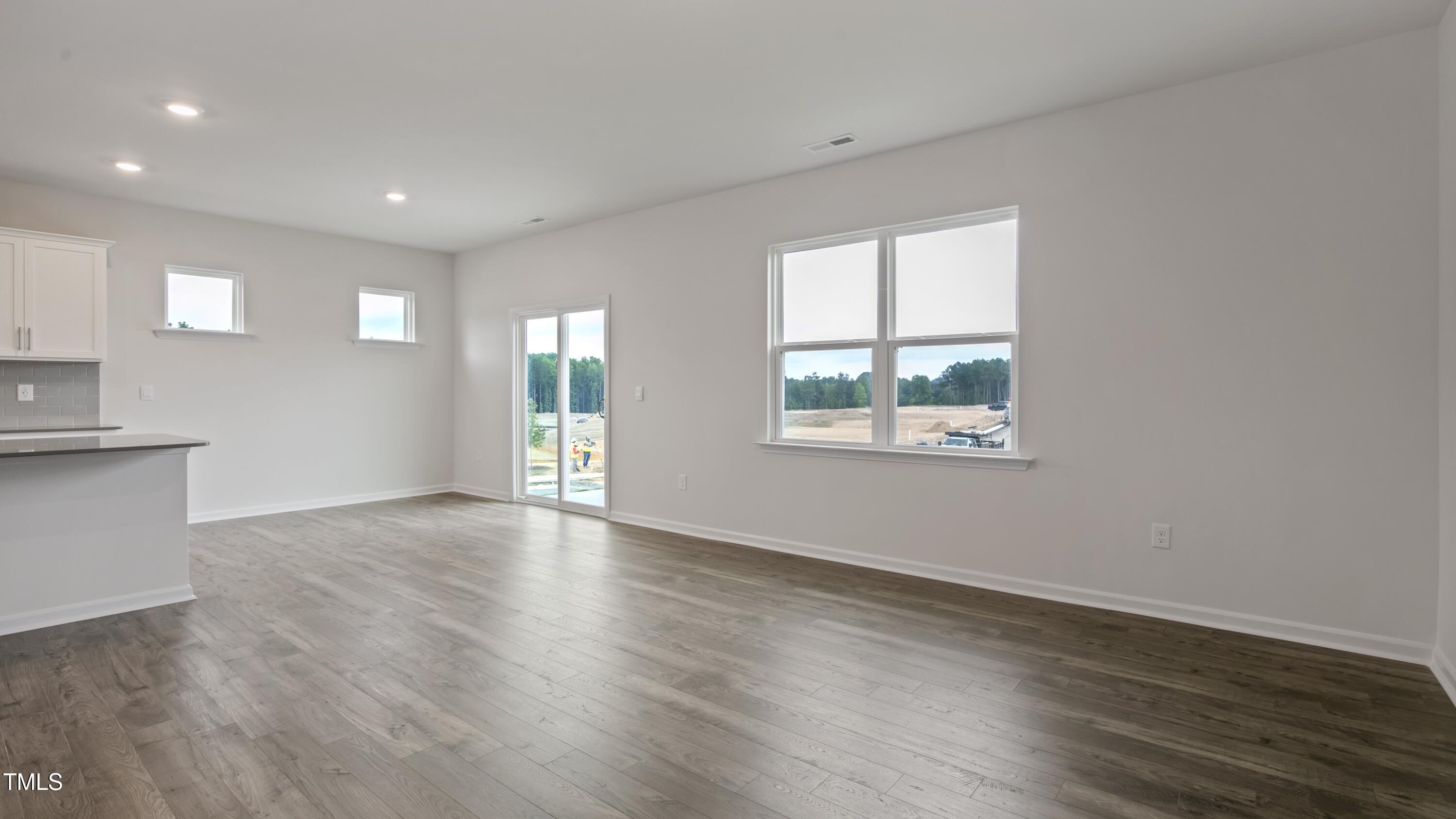 845 Comice Pear Way Willow Spring, NC 27592 - Photo 14 of 36 an empty room with wooden floor and windows