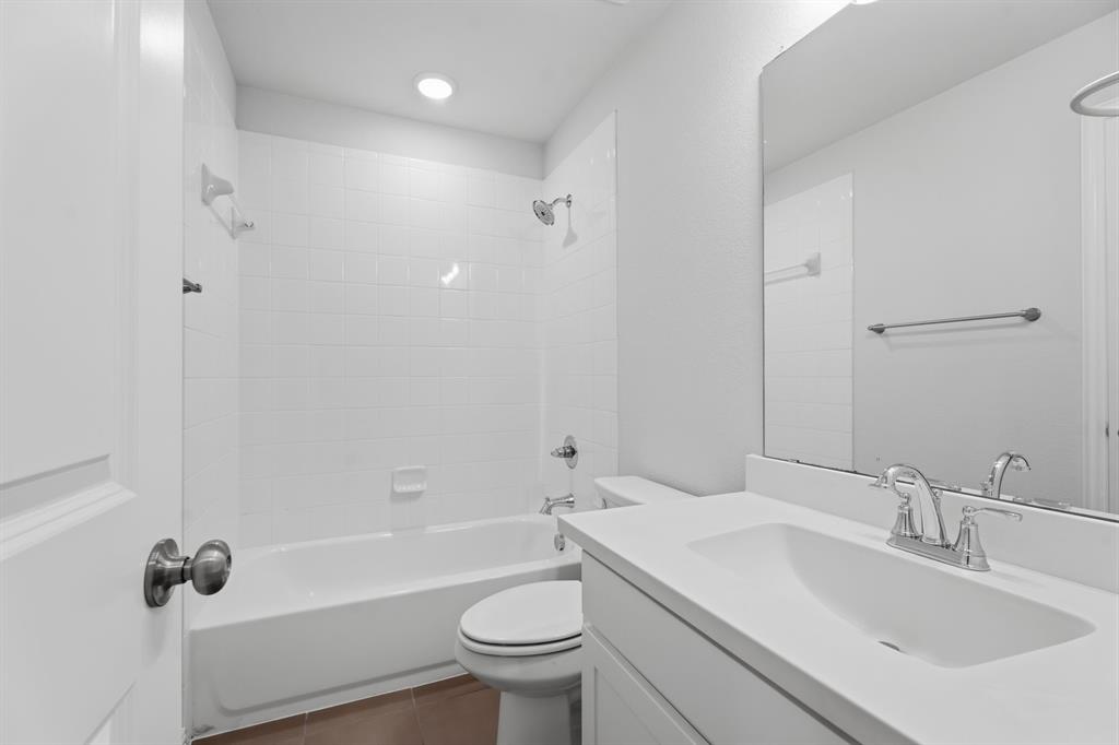 1316 Limestone Ridge Road Mansfield, TX 76063 - Photo 30 of 40 Bathroom featuring a white bathtub with subway tile surround, white vanity with integrated sink, chrome fixtures, and a large wall-mounted mirror