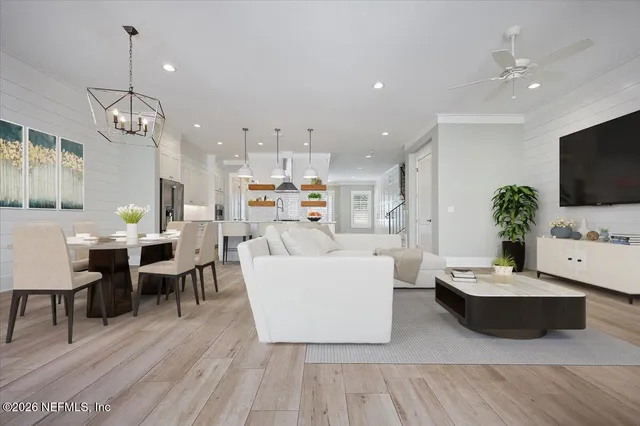 a living room with furniture kitchen view and a flat screen tv