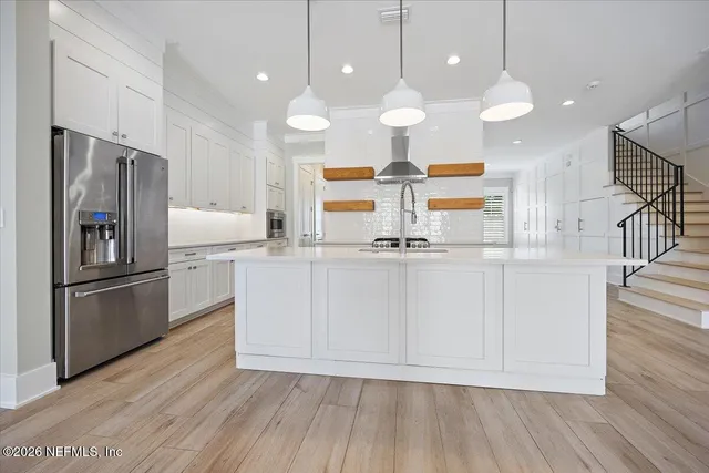a kitchen with white cabinets and stainless steel appliances