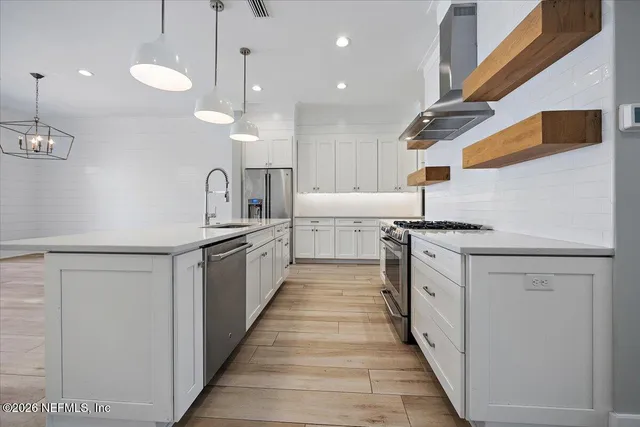 a kitchen with stainless steel appliances granite countertop a sink and a refrigerator