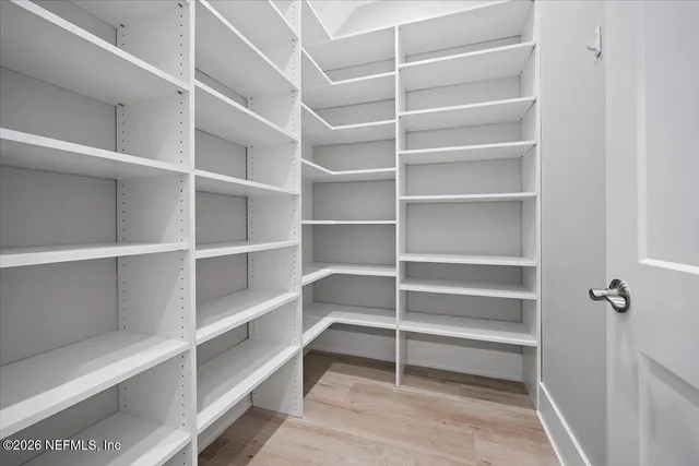 a view of walk in closet with empty racks