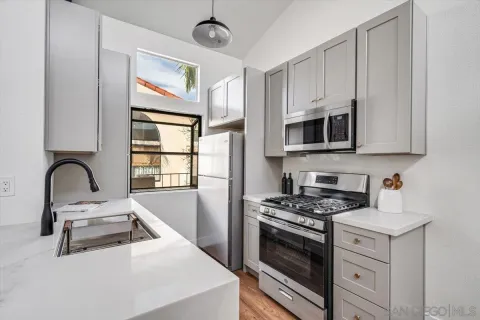 a kitchen with stainless steel appliances granite countertop a stove a sink and a microwave