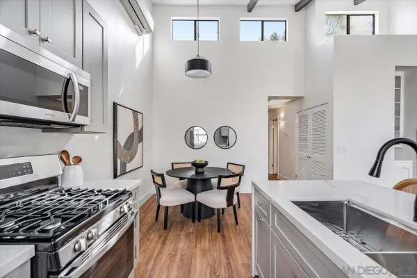 a kitchen with stainless steel appliances granite countertop a stove a sink dishwasher and microwave with wooden floor