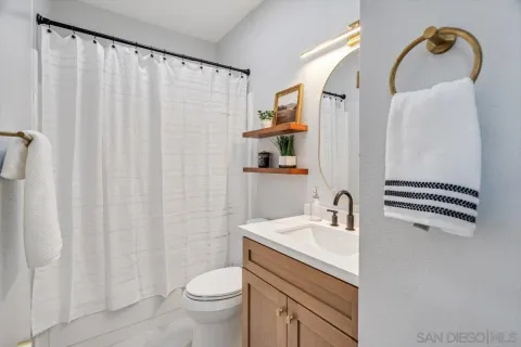 a bathroom with a sink a toilet and shower curtain