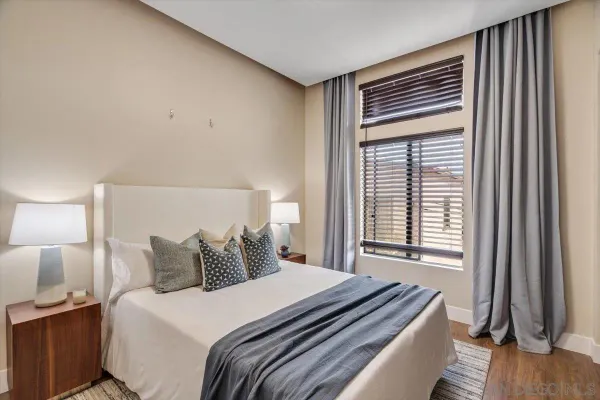 a bedroom with a bed and a flat tv screen on a dresser
