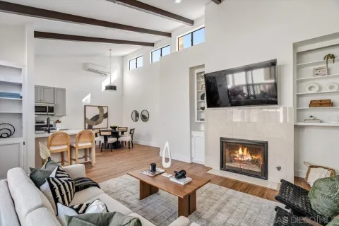 a living room with furniture a flat screen tv and a fireplace