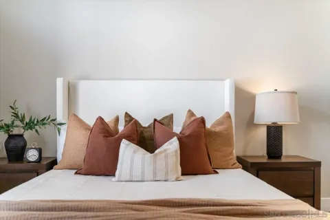 a large bed sitting in a bedroom next to a lamp