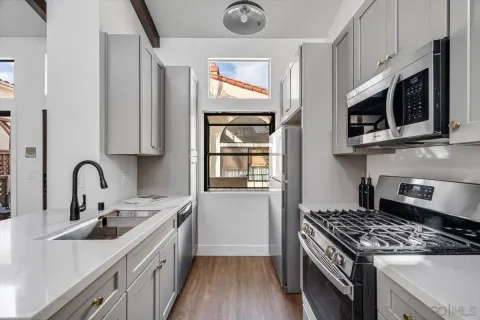 a kitchen with stainless steel appliances granite countertop a stove a sink and a microwave