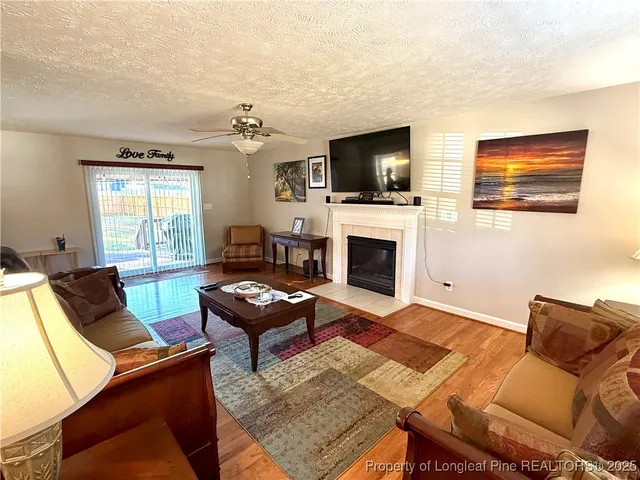 a living room with furniture a flat screen tv and a fireplace
